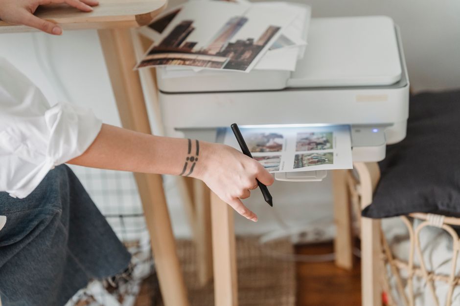 A home printer producing photographs beside a desk