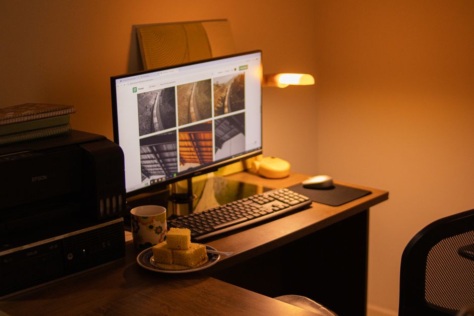 A printer beside a desktop computer in a home office